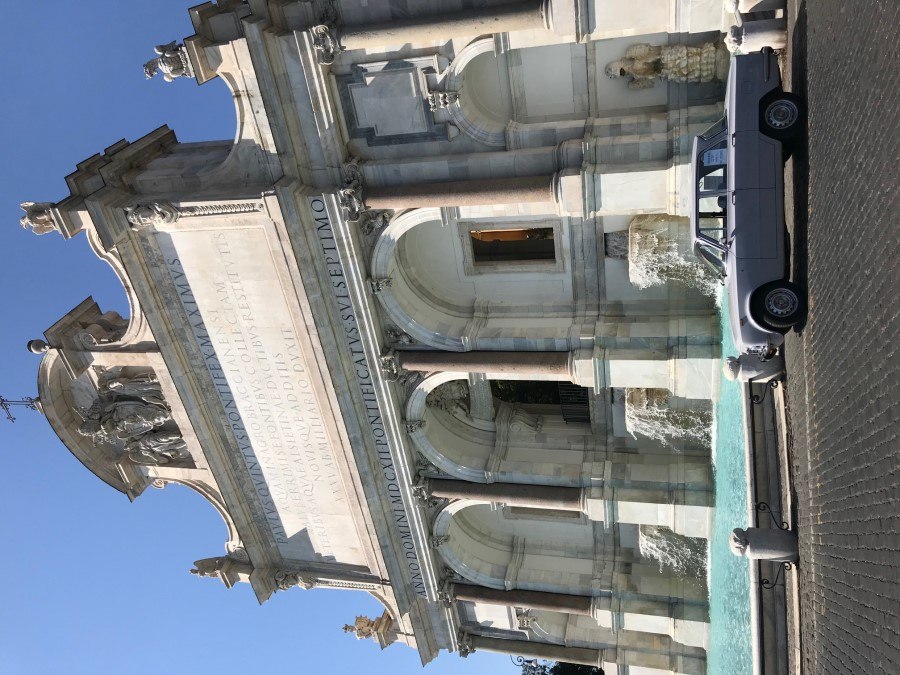 White vintage sedan parked in front of Acqua Paola Fountain in Rome